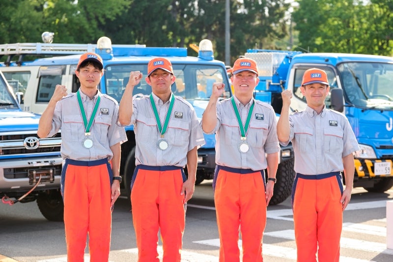 北海道本部代表選手に選ばれた4名の隊員たちと、JAFロードサービスカー