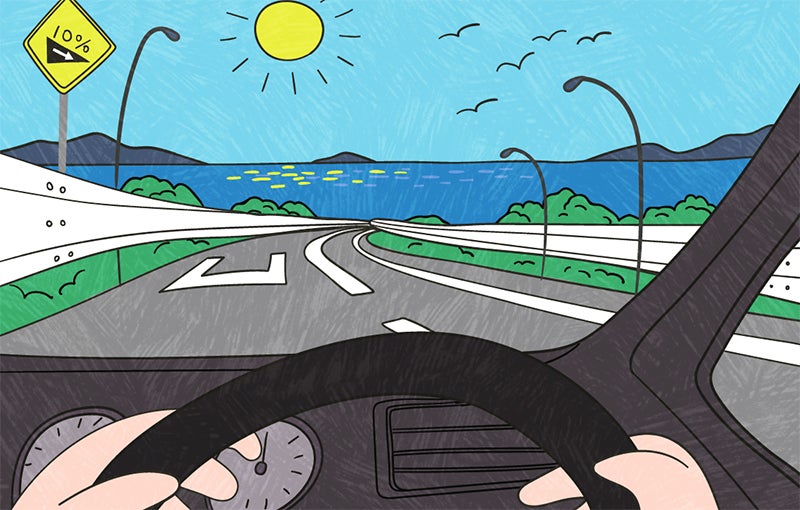 勾配の急な下り坂を走るクルマ