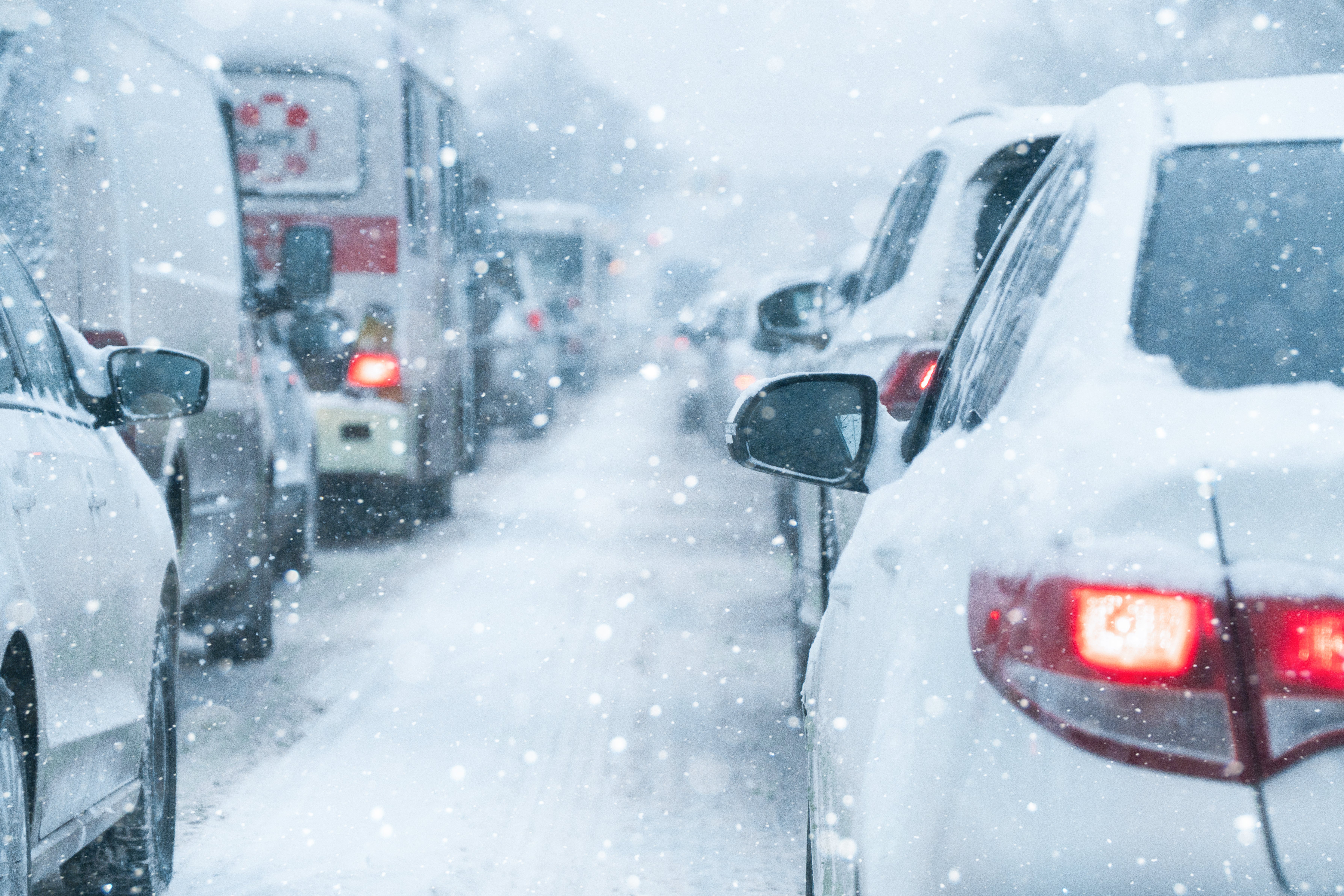 猛吹雪で視界が効かなくなった雪国の渋滞。ホワイトアウトの主な原因となる降雪と地吹雪のイメージ