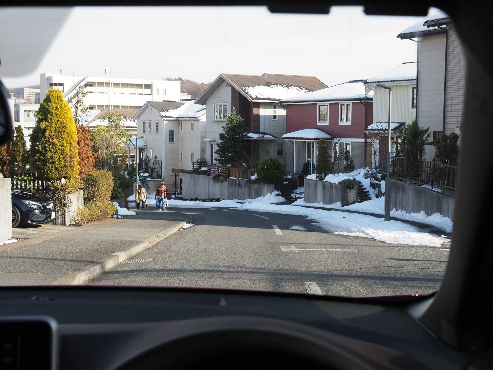 雪が残る下りカーブに差しかかる自車