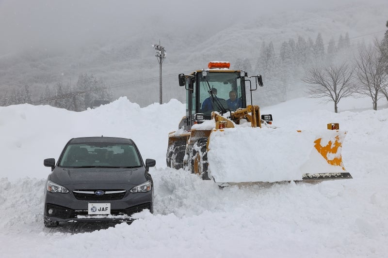 ホイールローダーで運んだ雪でクルマを埋めていく様子