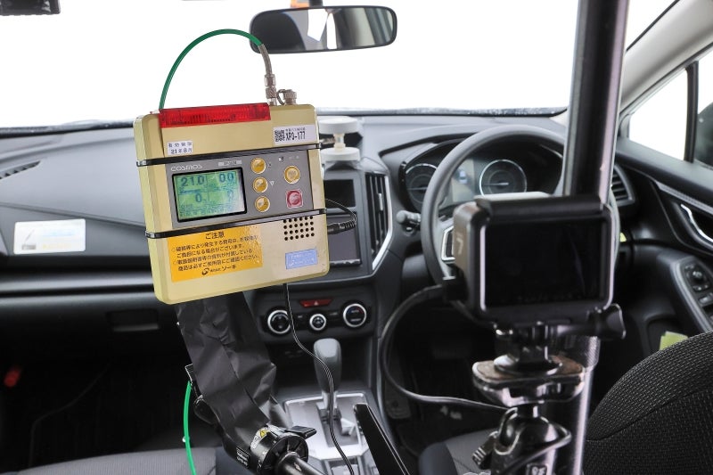 ガソリン車の車内で一酸化炭素(ppm)、酸素の濃度(%)を計測する様子