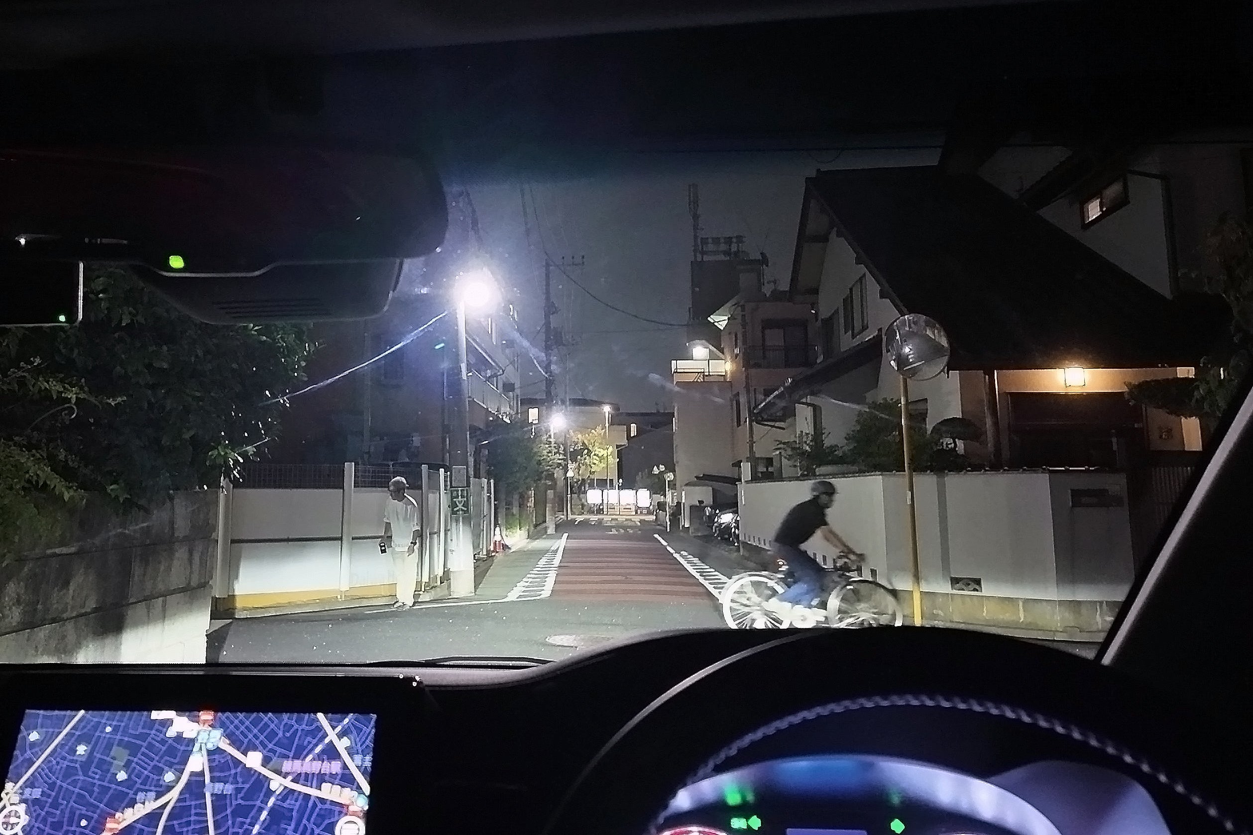 夜の住宅街の交差点を通過する自車