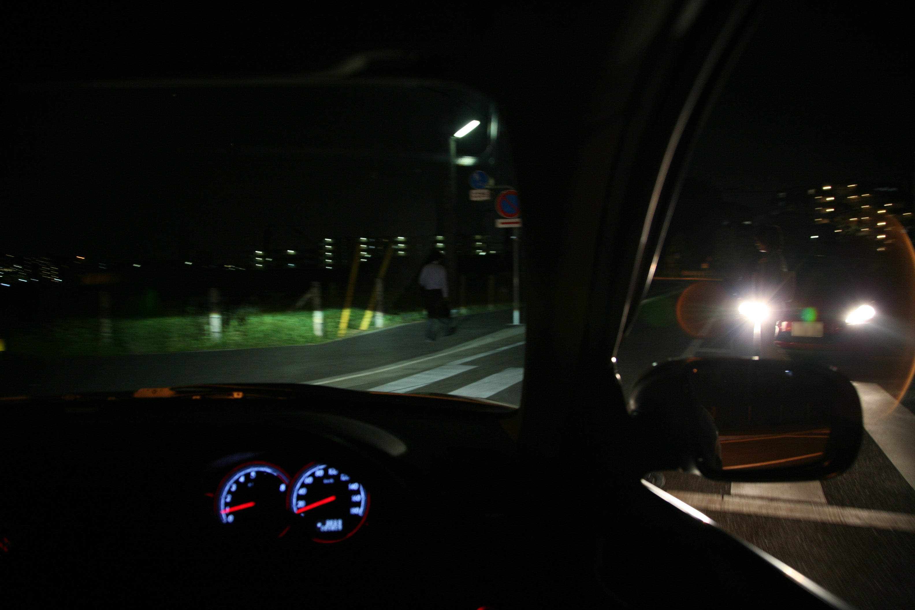 夜間に信号機のない交差点を右折する自車