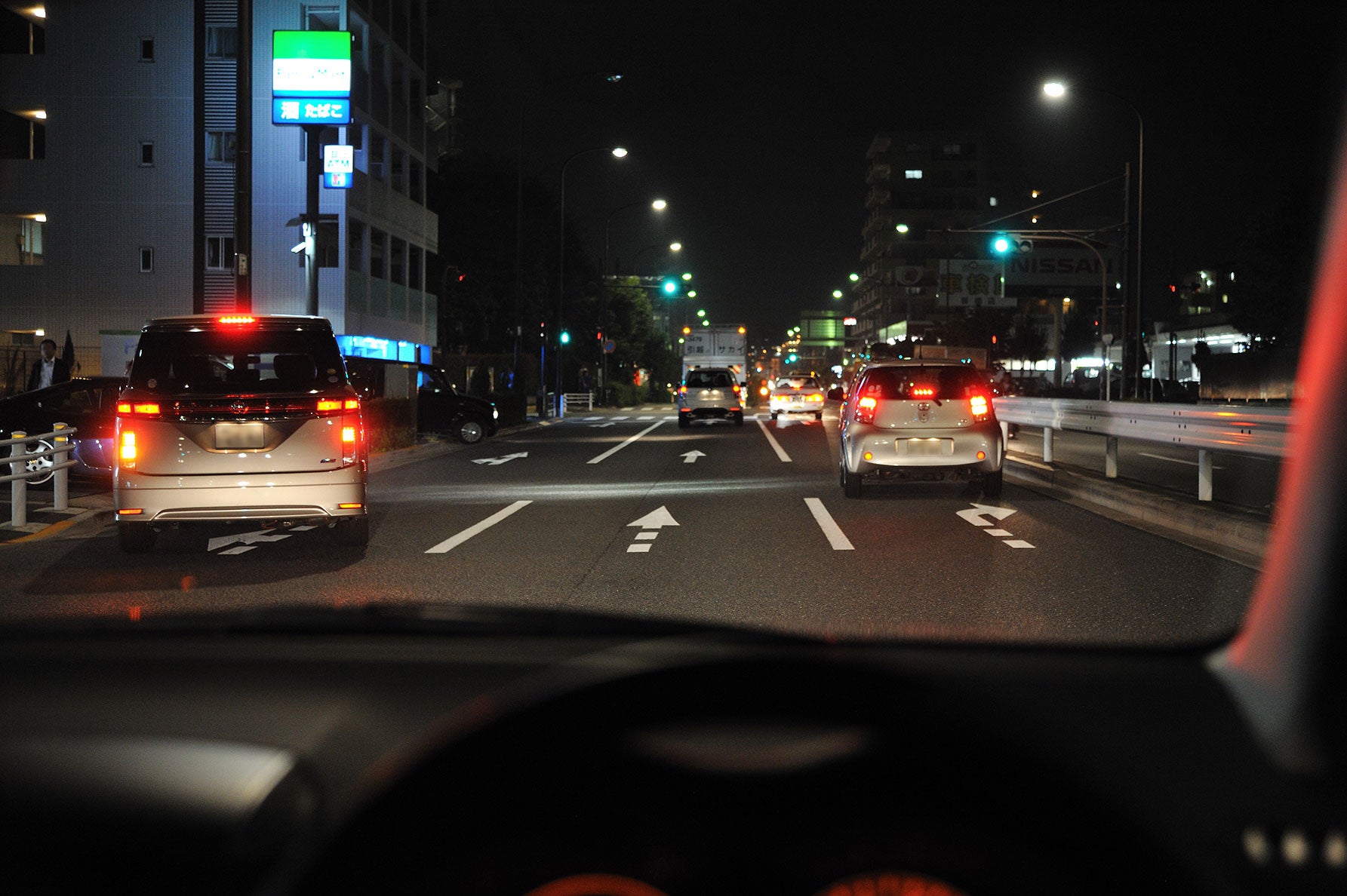 夜間、幹線道路の交差点手前を通過する自車