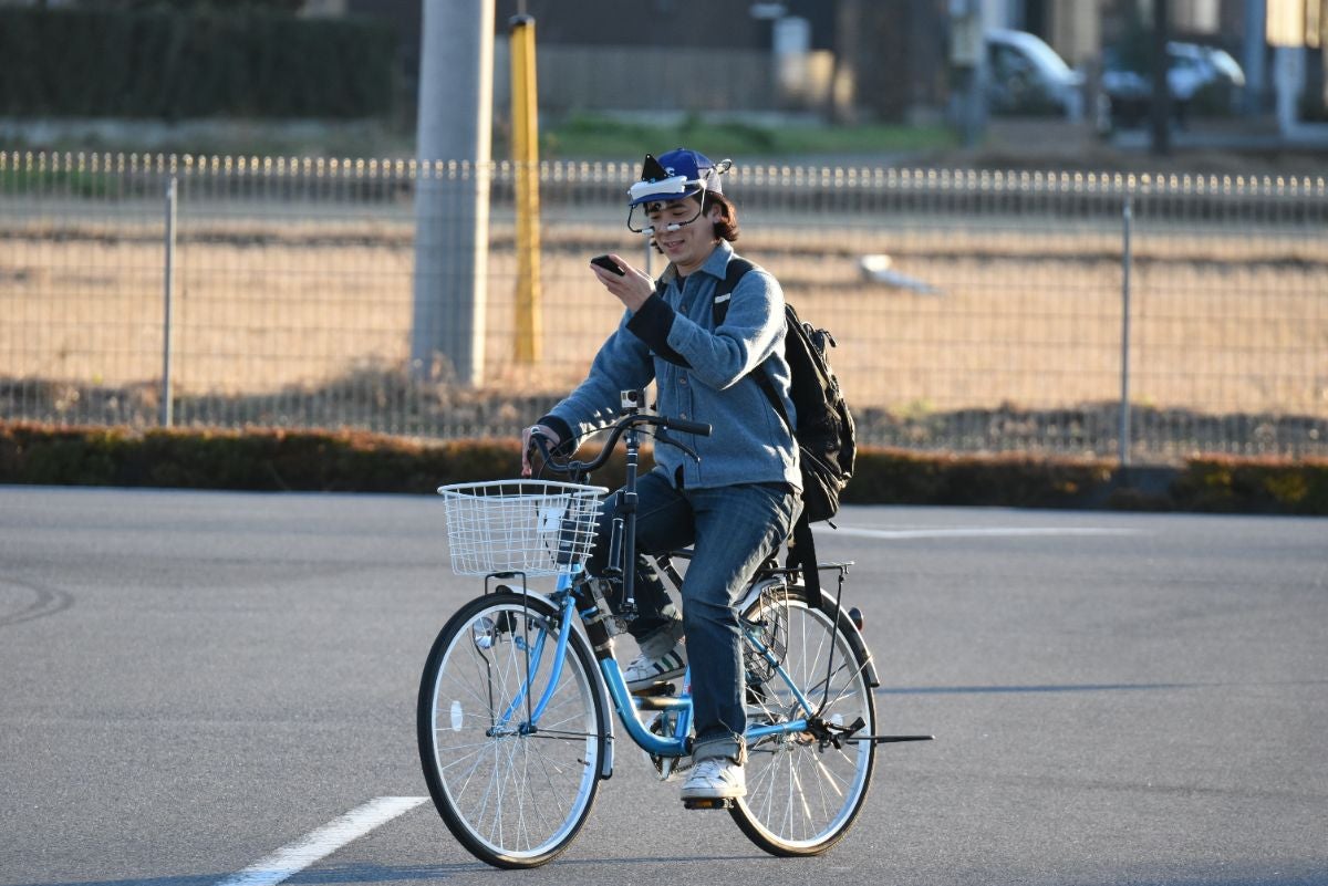 自転車乗車中、ながらスマホをする女性