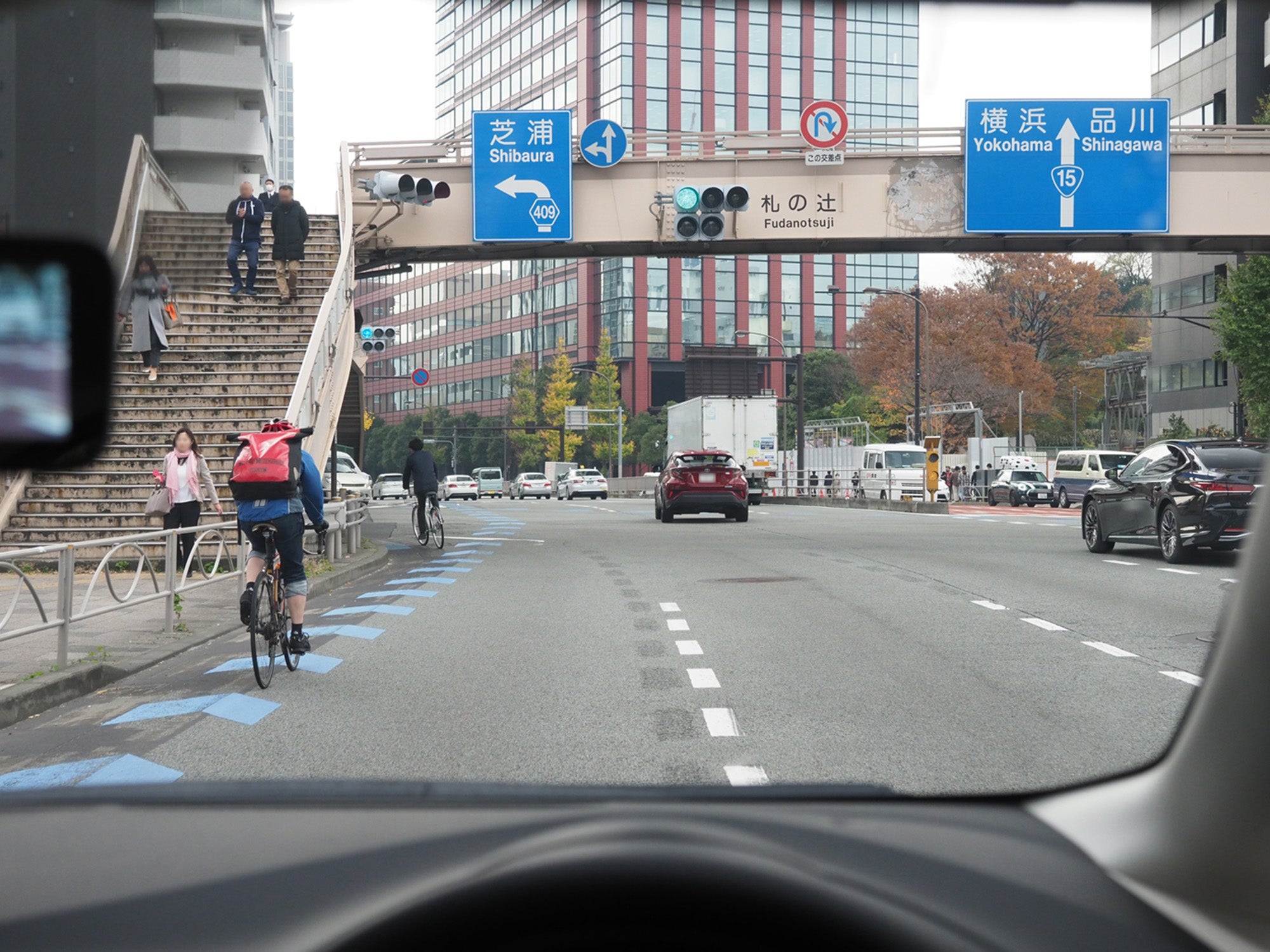 自転車がいる左折レーンを通り、交差点を左折しようとする自車