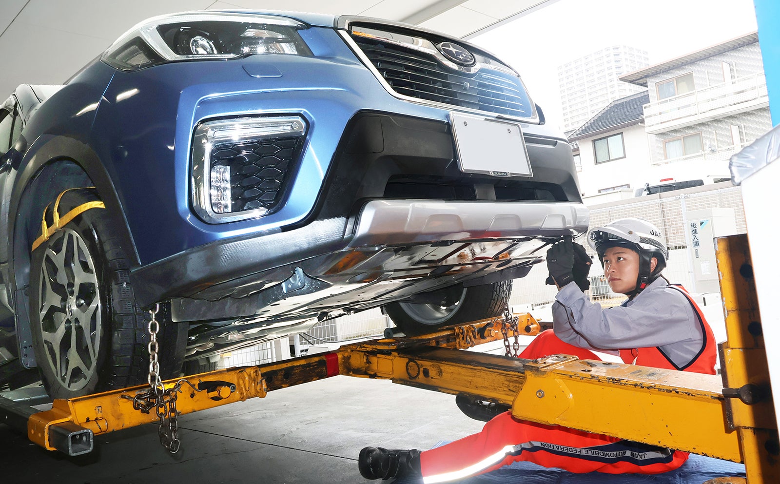 レッカー車でクルマのフロントを持ち上げて作業をする畠澤隊員