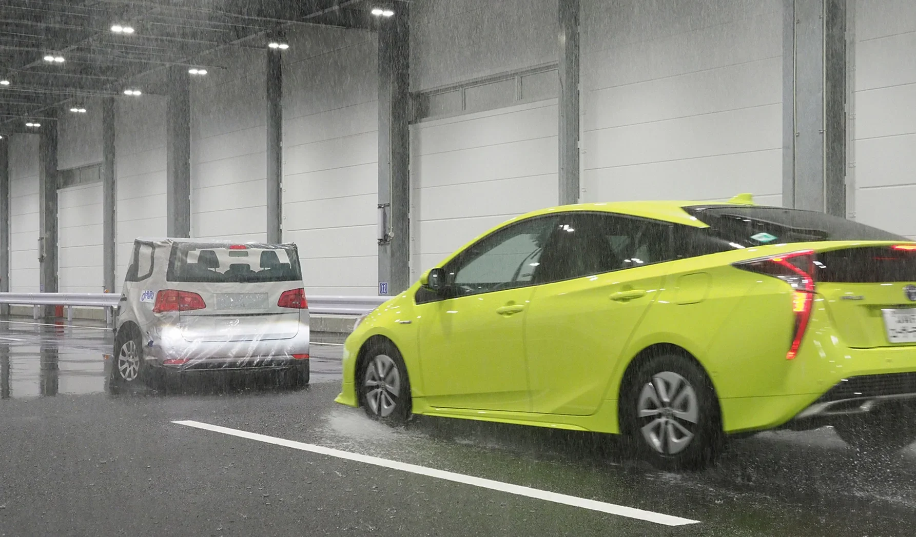 大雨を模したテストコースで、バリアにぶつかりそうになるクルマ