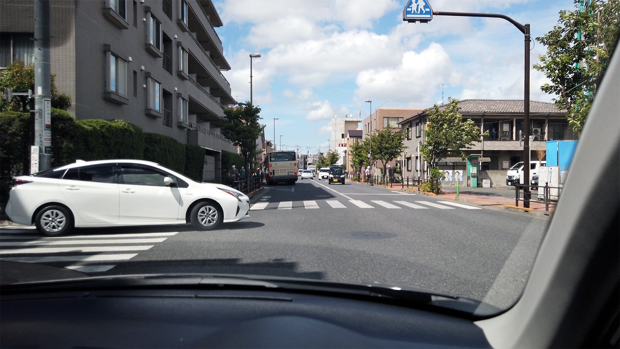 交差点の左折先の狭い道路に車がいるので、その車が先に出るのを待っている自車