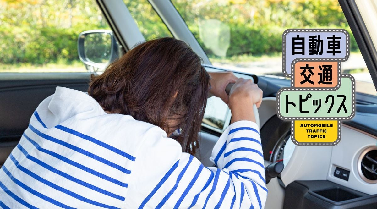 車の運転席で頭を抱える女性と、右上の「自動車交通トピックス」というテキストロゴの画像