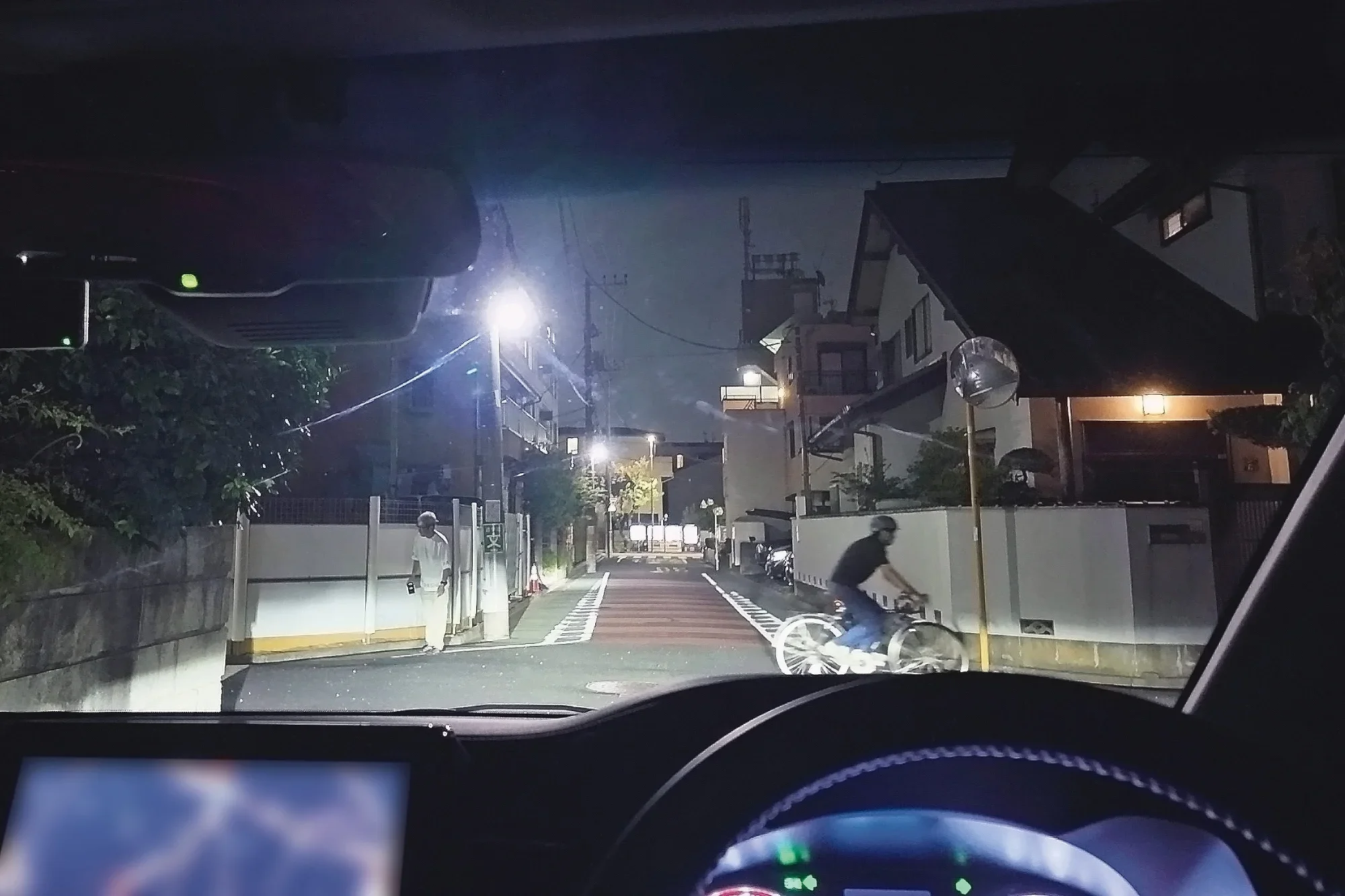 夜間の住宅街の交差点を走る車から見た写真