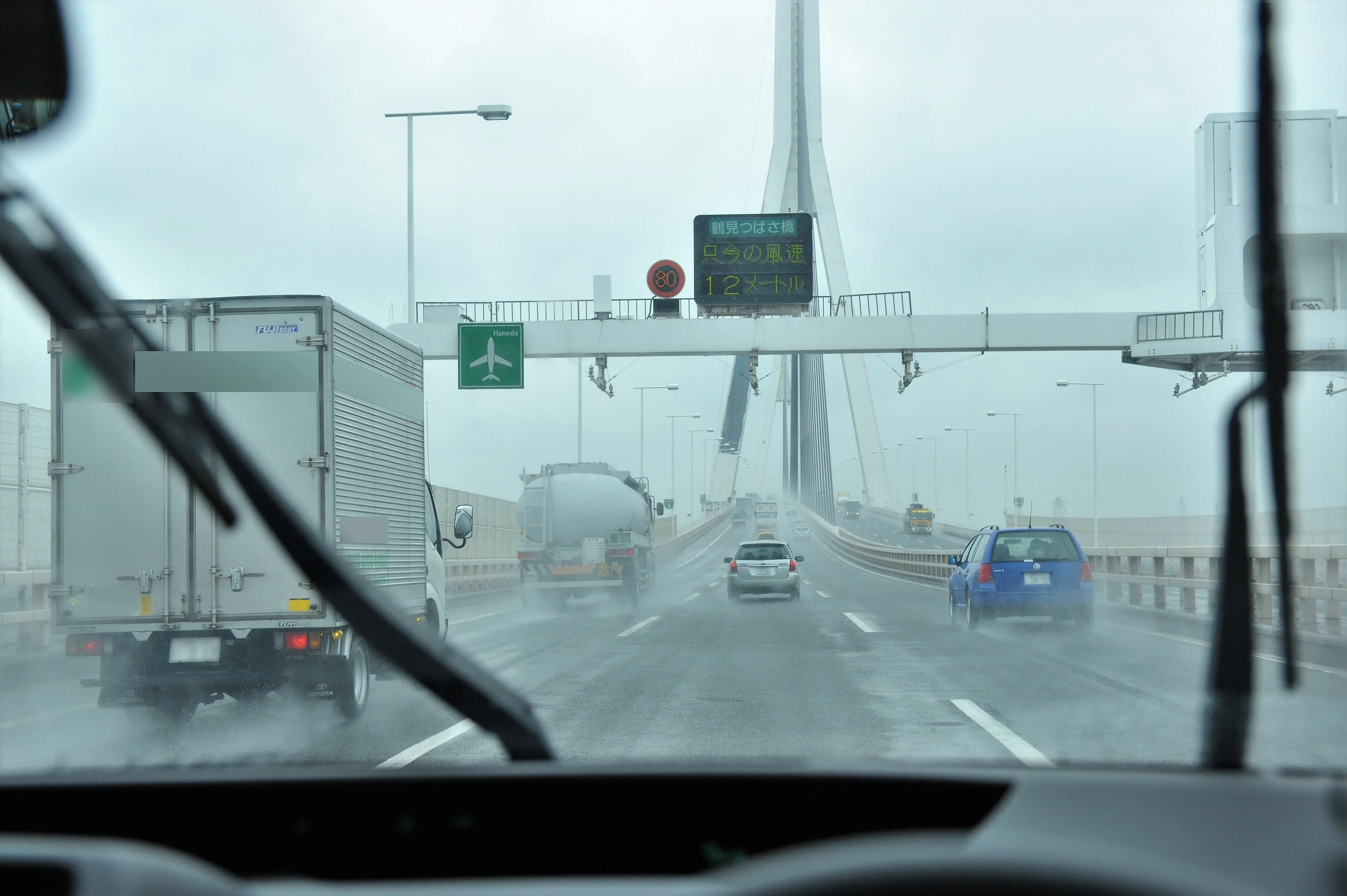 雨天の橋の上を走る車から見た写真
