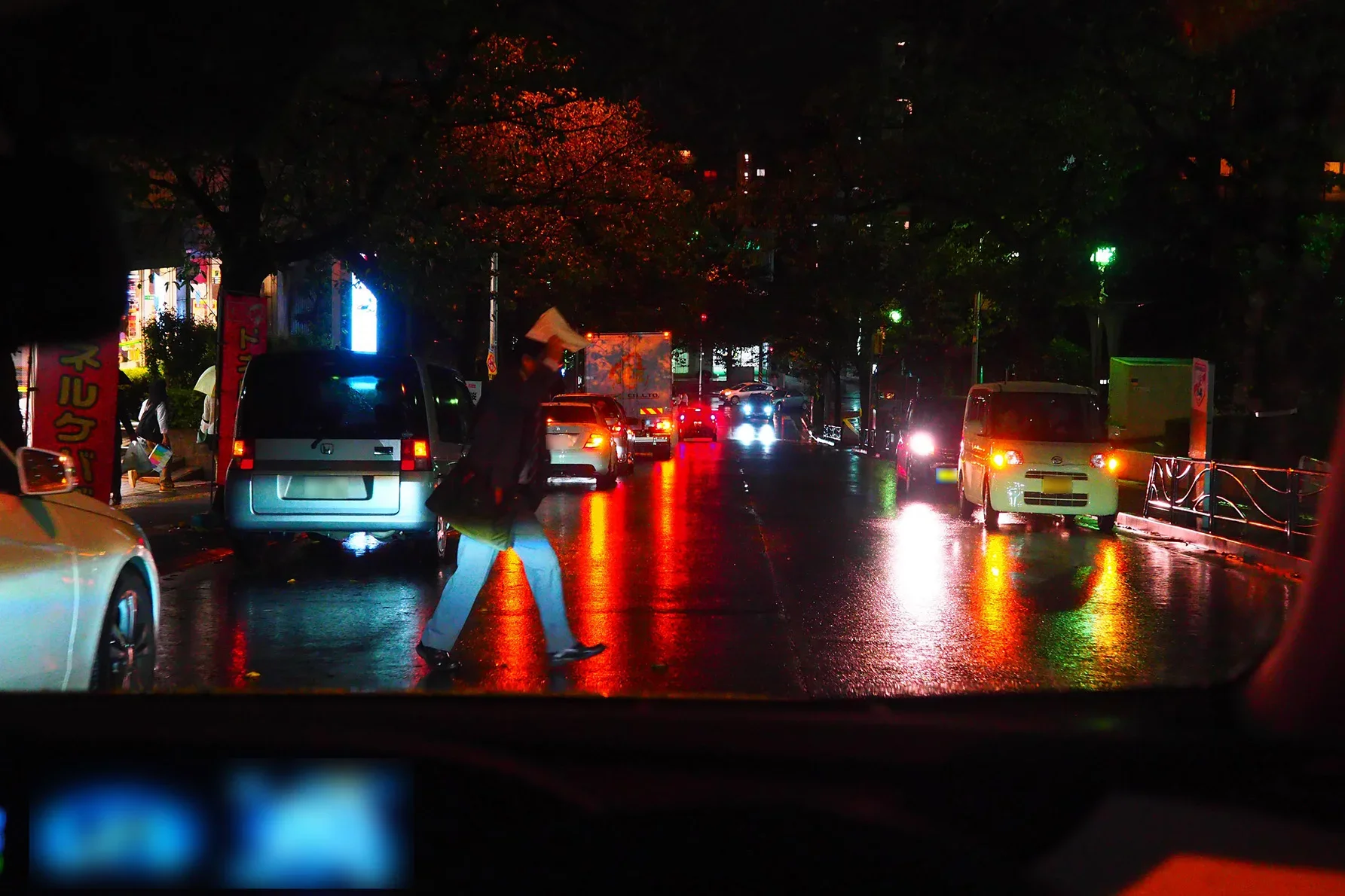 雨の夜の駅前を走る車から見た写真