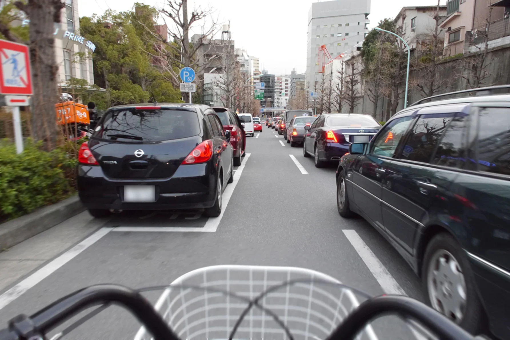 駐車車両と停止車両の間を走る自転車