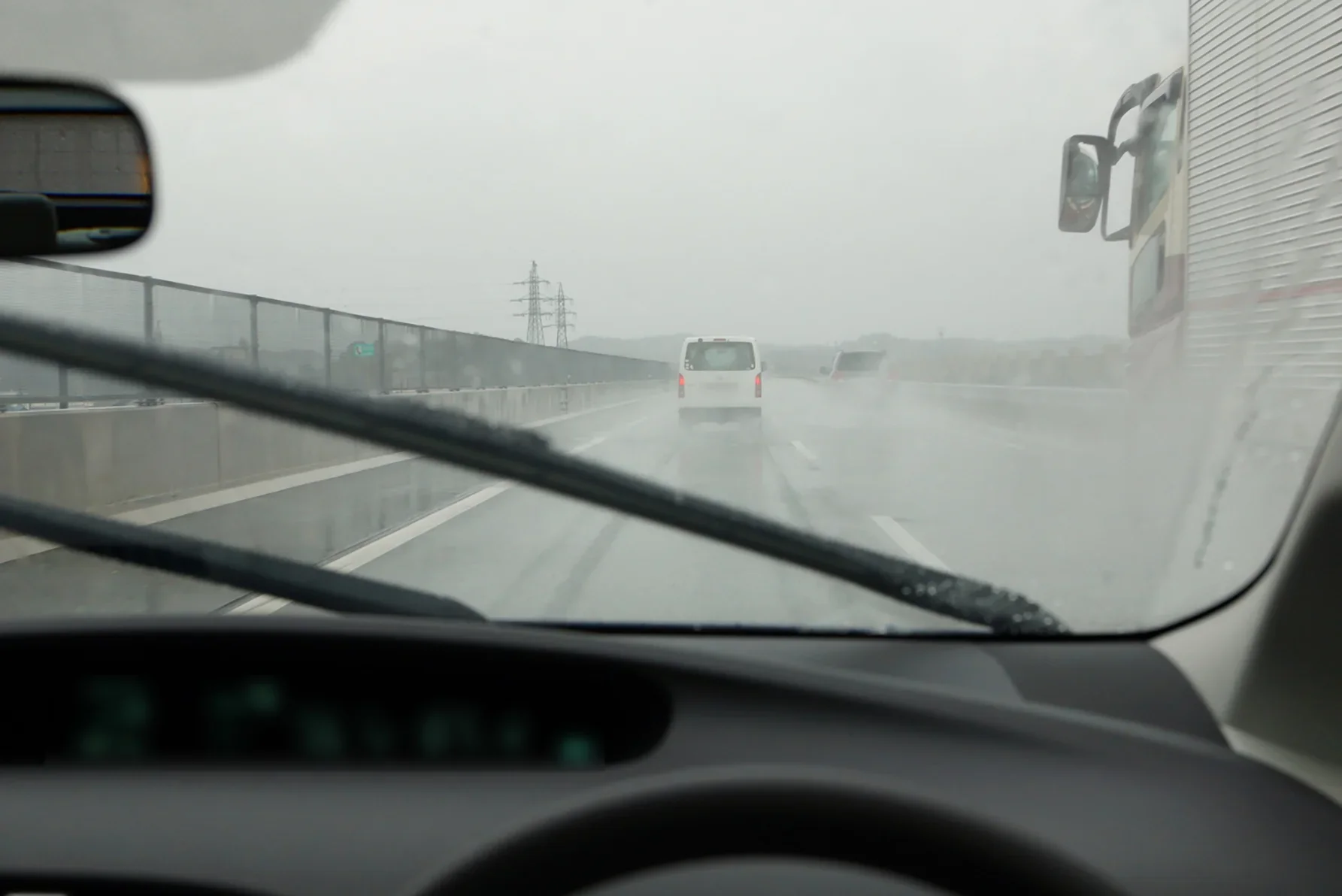 雨天の高速道路を走る車から見た写真