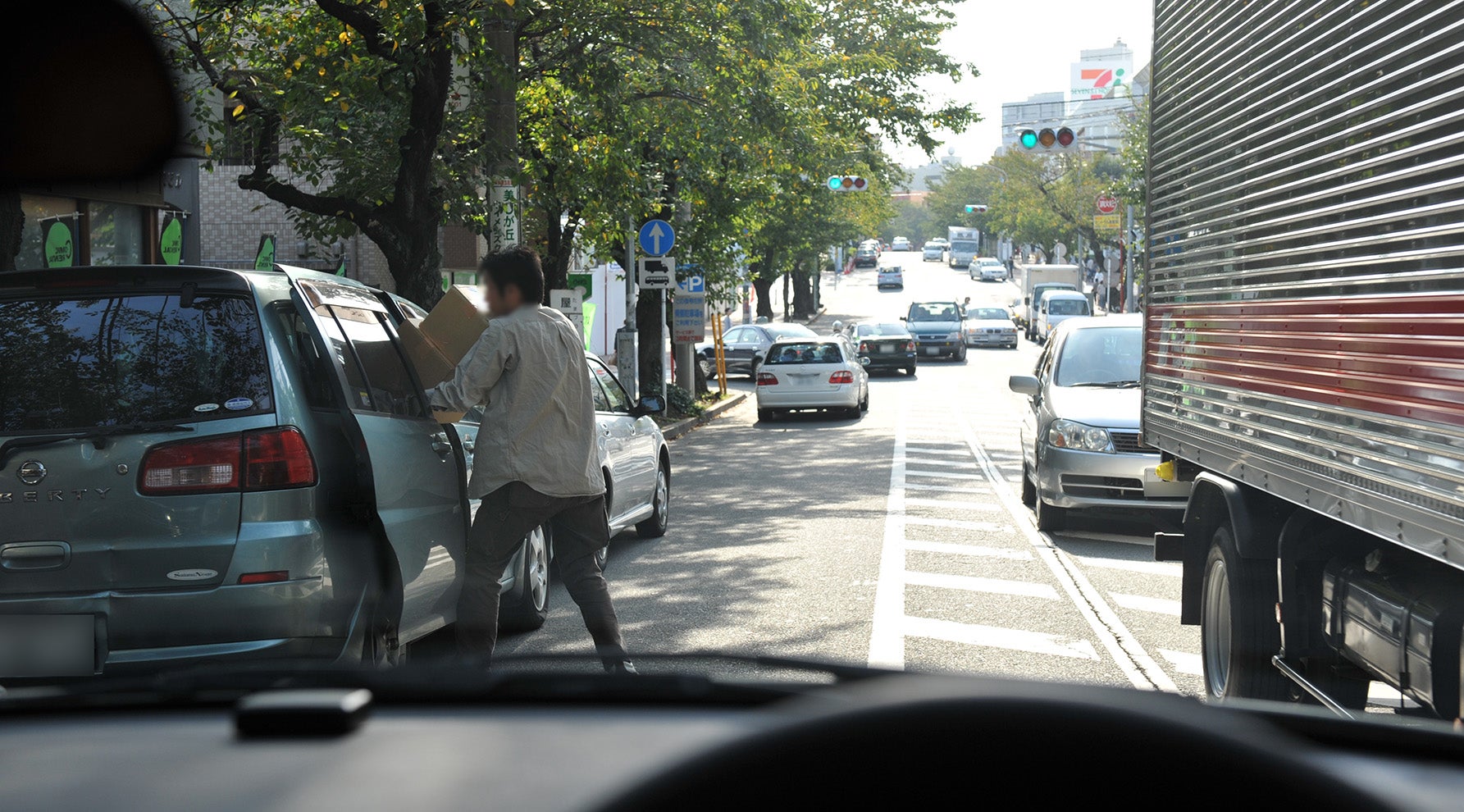 駐車車両の中から出て来る人