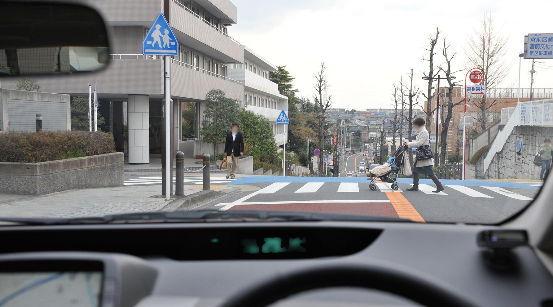 ベビーカーを押して横断歩道を渡っている女性