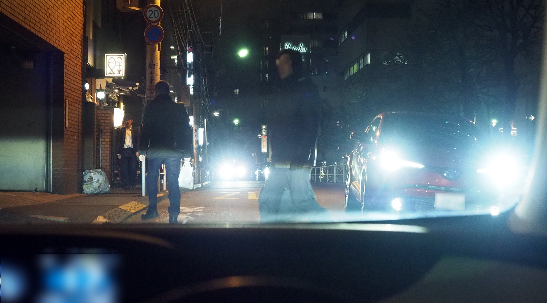 夜間の交差点を横断して来る歩行者