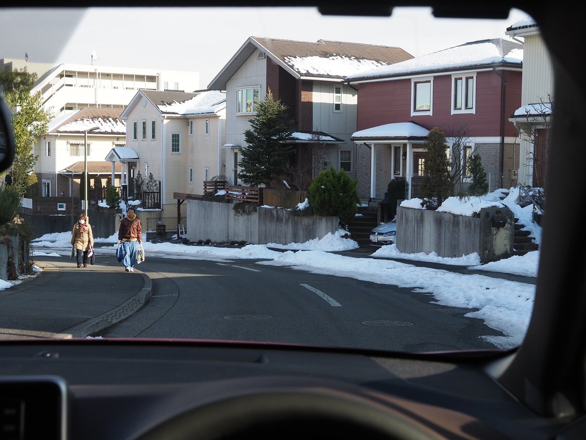 雪が残る下りカーブを走る自車