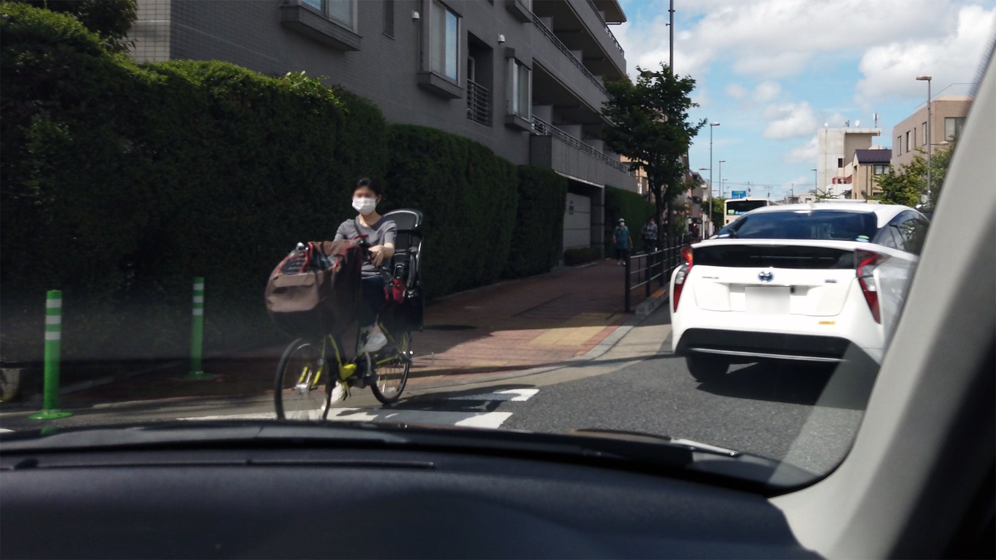 白い車が出た直後に交差点を横断して来る自転車