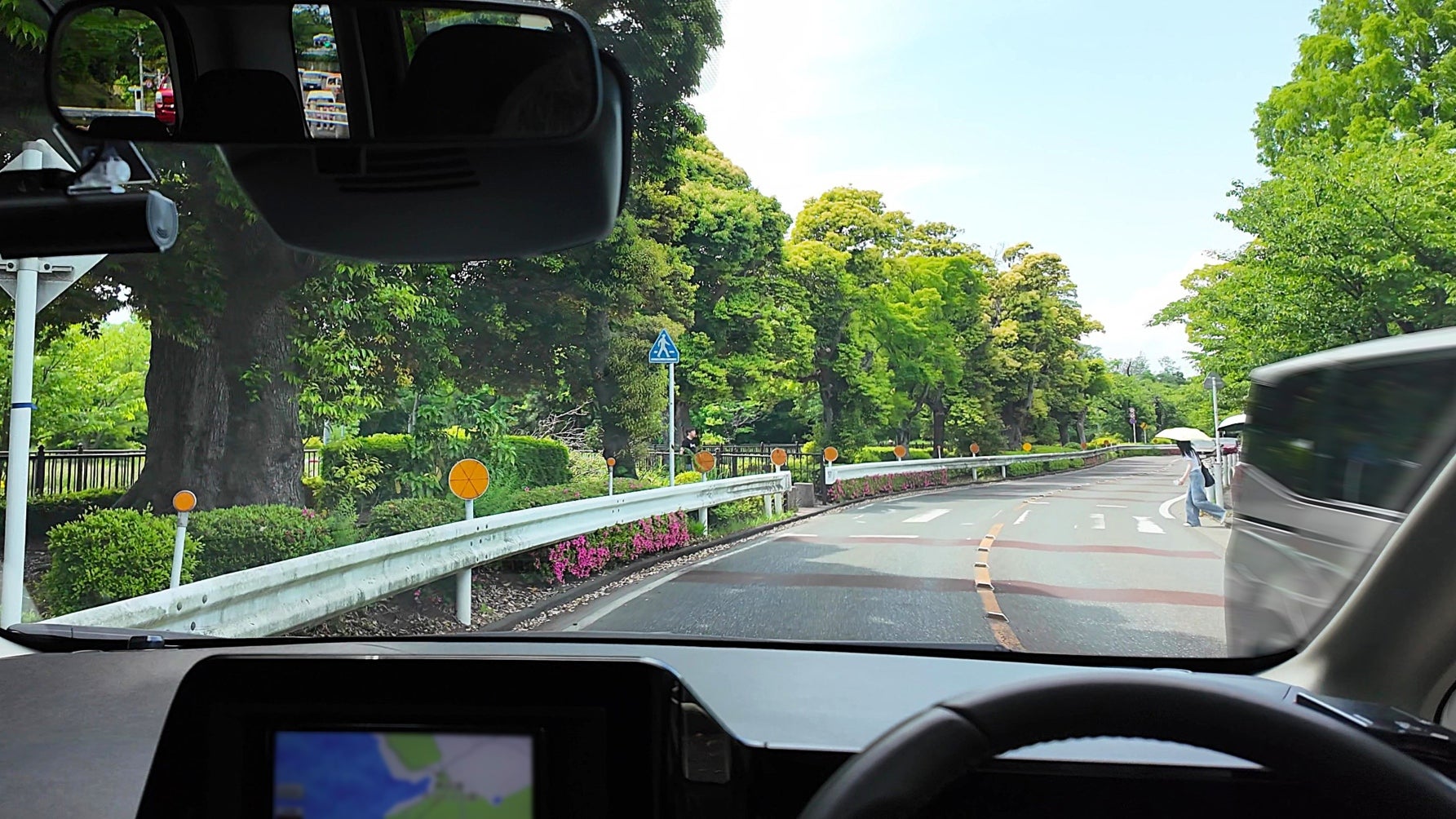 対向車の切れ目で横断歩道を渡り始める歩行者