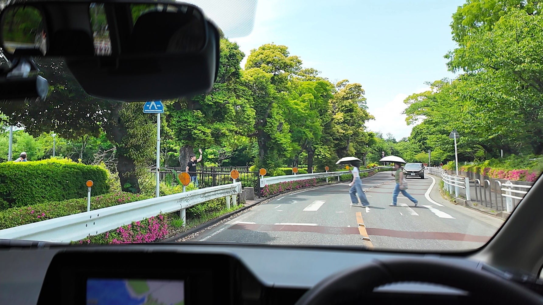 カーブの先にある横断歩道を渡る歩行者