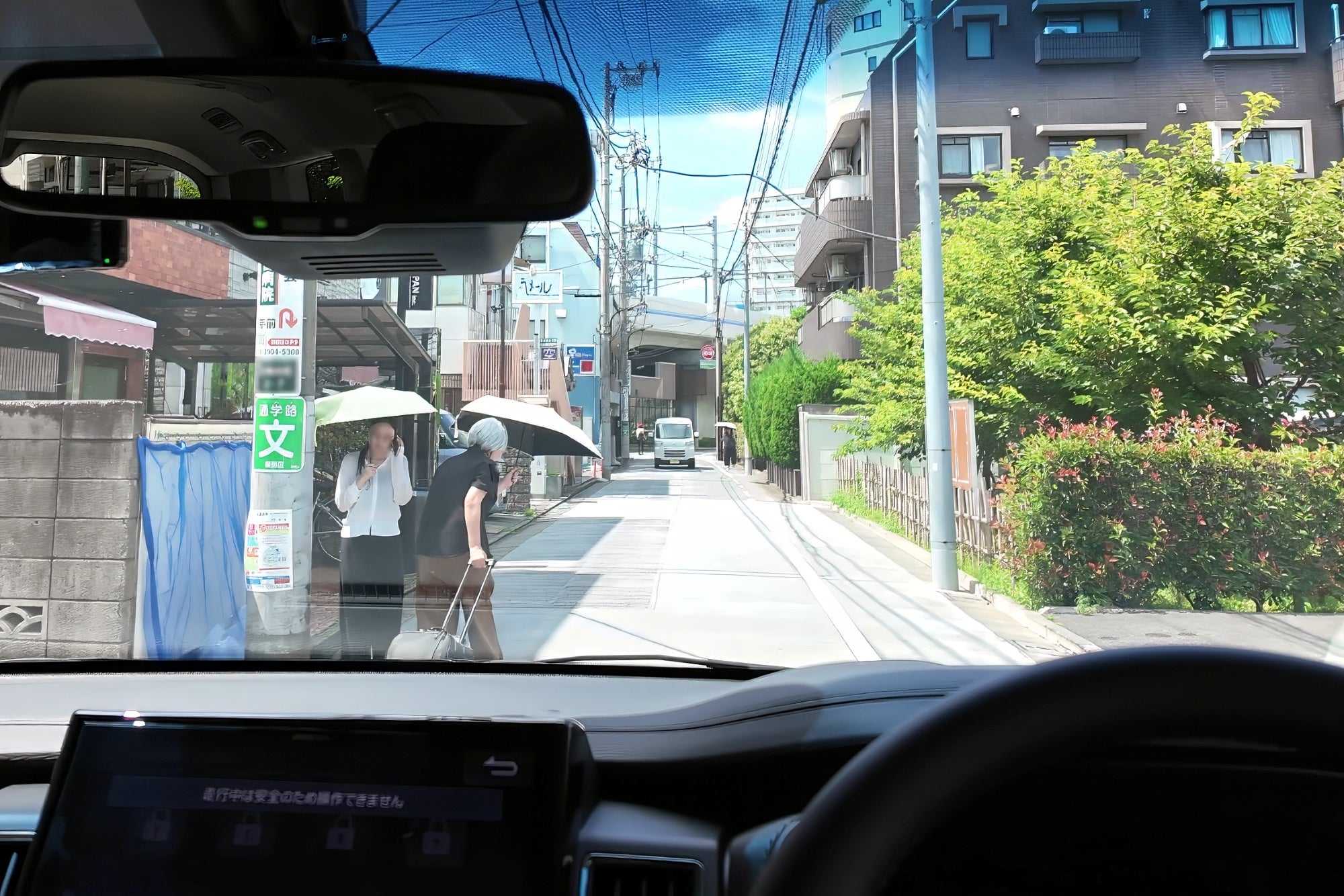 道路左側を歩く2人がすれ違う際、車道側へ出てくる