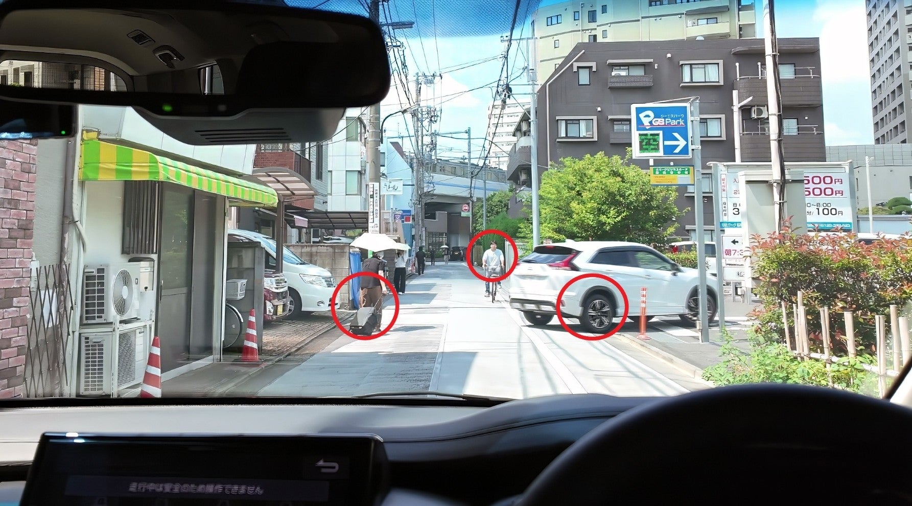 生活道路で注意すべき歩行者、自転車、駐車場に入ろうとする車を赤い丸で示した場面 